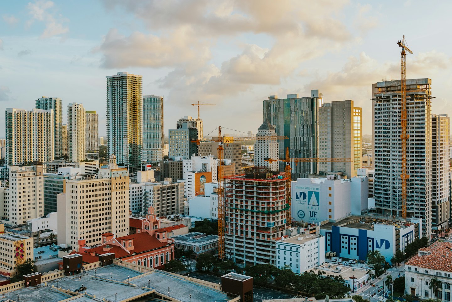 Modern skyscrapers and construction cranes tower over the city skyline.