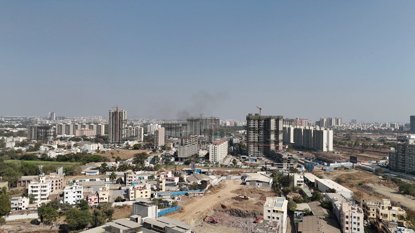 Construction cranes rise above a growing urban development site.